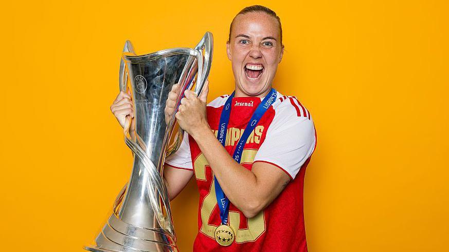 Beth Mead holding the UEFA Women's Champions League Trophy and cheering