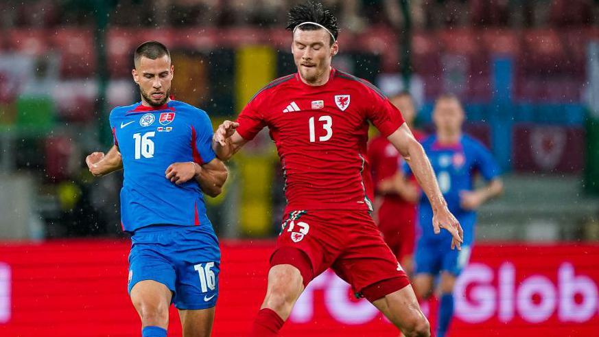 David Hancko (left) of Slovakia in action against Kieffer Moore of Wales 