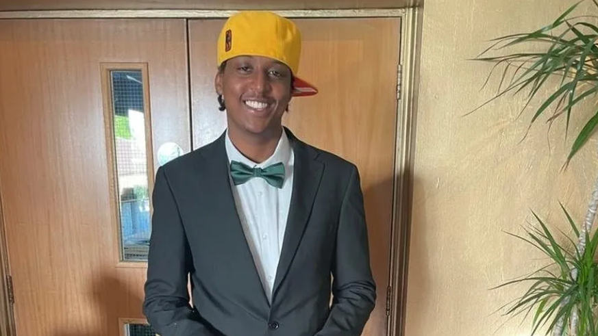 Mr Kinuthia dressed in a suit jacket, green bow tie and yellow baseball cap