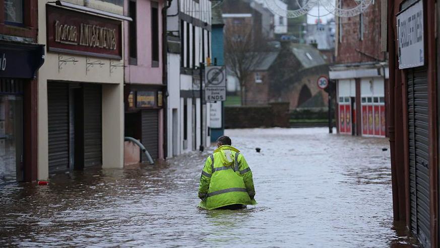 A man walking past Norona Amusements in Dumfries