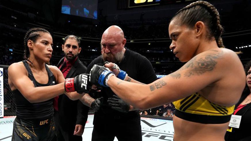 Julianna Pena and Amanda Nunes bump fists before a fight