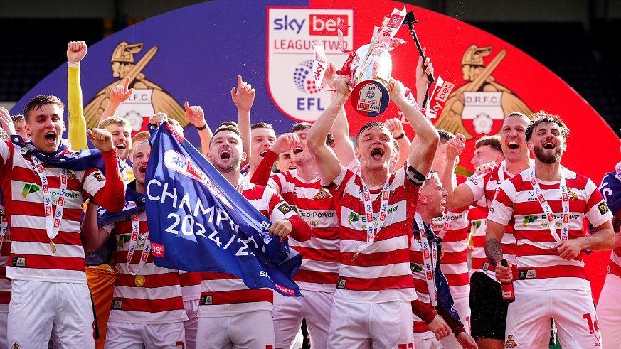 Doncaster Rovers players lift the League Two trophy
