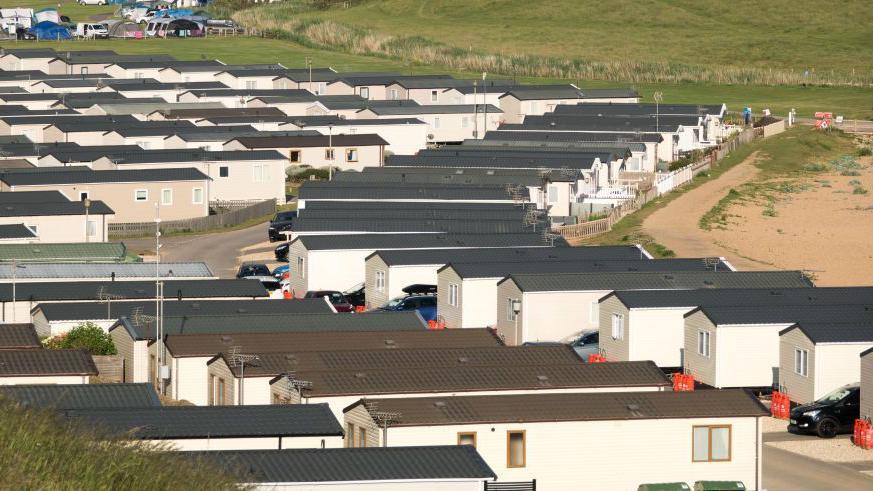 Caravans in a caravan site next to a beach