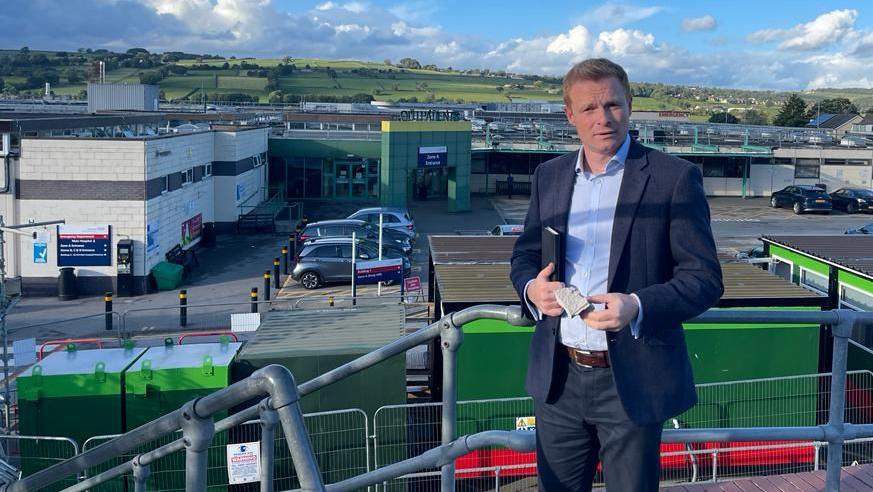 Robbie Moore MP standing outside the hospital