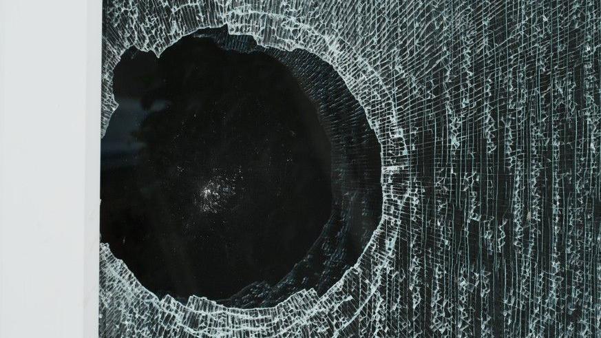 Broken window. It is a black, round hole with peripheral cracking around it.