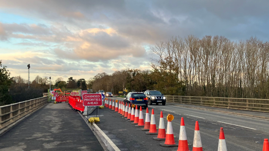 Cars travelling along Oxford Road in Abingdon near the Lodge Hill junction - a red sign says "Changed Priorities Ahead".