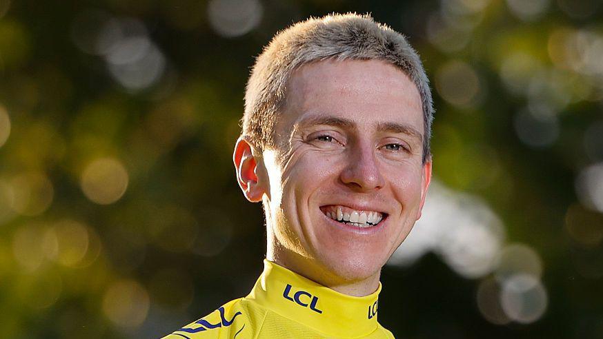 Head and shoulders view of a smiling Tadej Pogacar, in yellow team kit