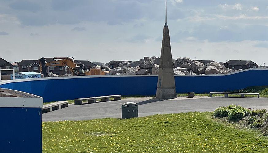 The grassed area round the obelisk surrounded by blue hoardings and a huge pile of rubble during the sea defence works