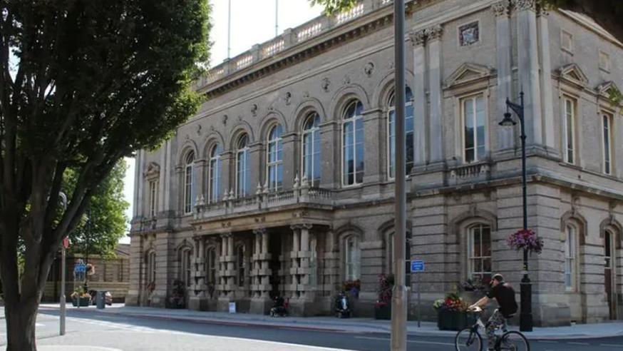 A cyclist rides past the two-storey North East Lincolnshire Council town hall in Grimsby 