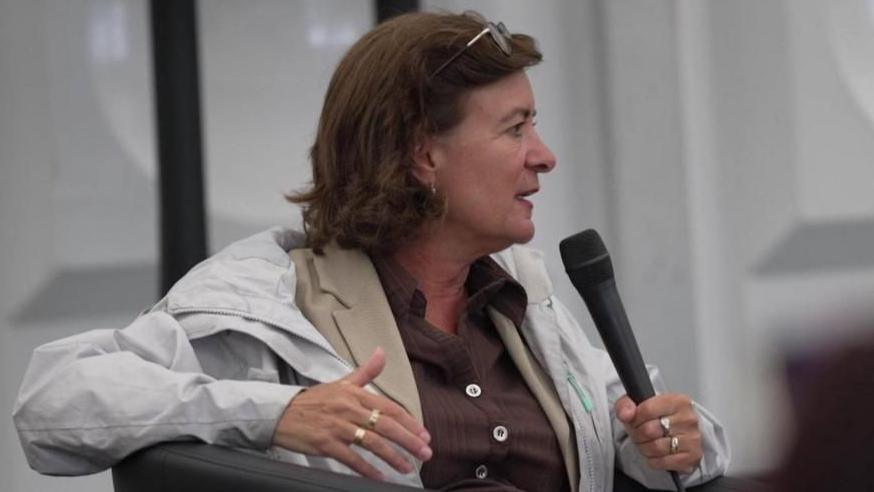 Eluned Morgan holding a microphone and wearing a white jacket and beige top