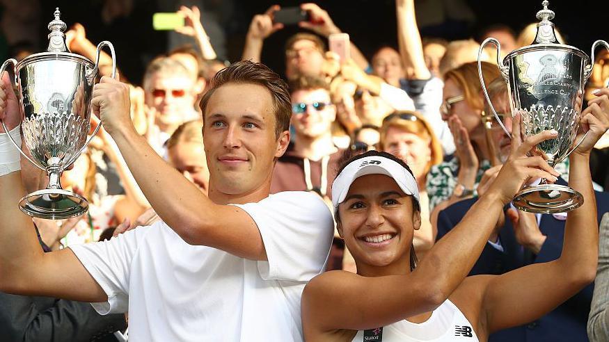 Heather Watson and Henri Kontinen hold up their Wimbledon trophies