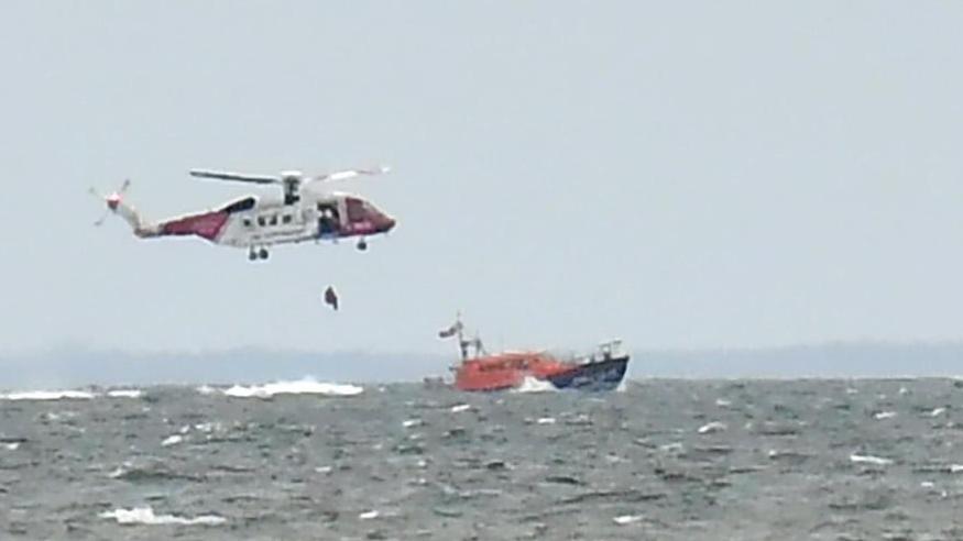 The coastguard helicopter and boat out at sea