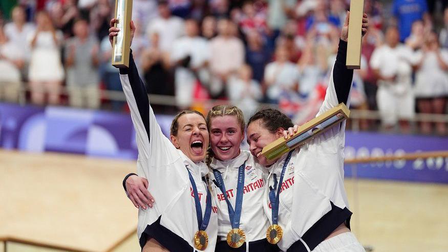 Great Britain's Katy Marchant, Emma Finucane and Sophie Capewell celebrate with their gold medals won in the Women's Team Sprint finals at the National Velodrome, Saint-Quentin-en-Yvelines, on the tenth day of the 2024 Paris Olympic Games in France.