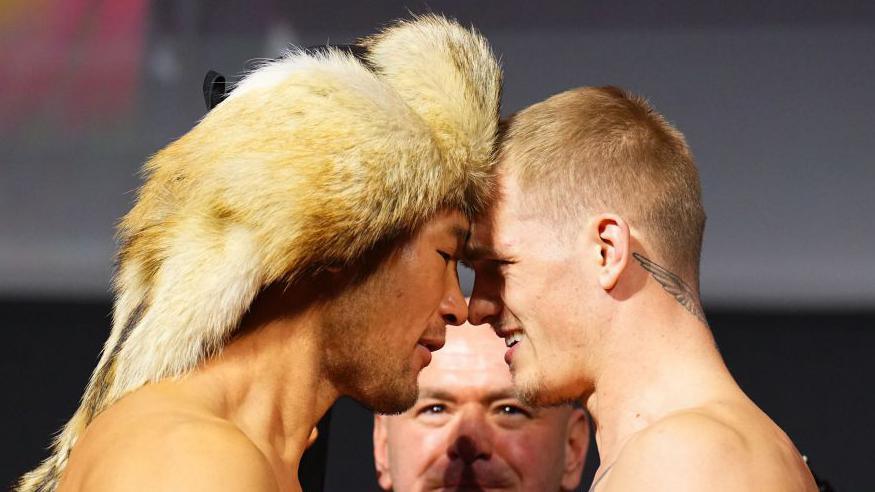 Ian Machado Garry (R) and Shavkat Rakhmonov face off at the a weigh-in