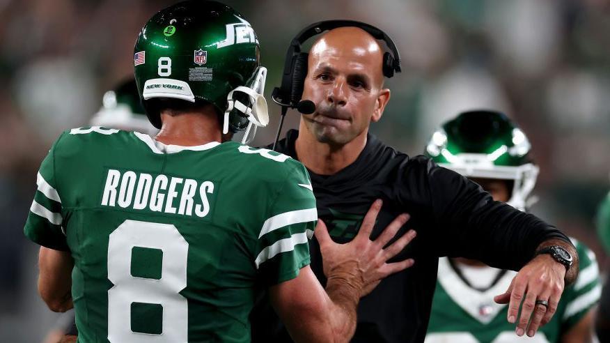 Quarterback Aaron Rodgers pushes away New York Jets coach Robert Saleh as he tries to give him a hug