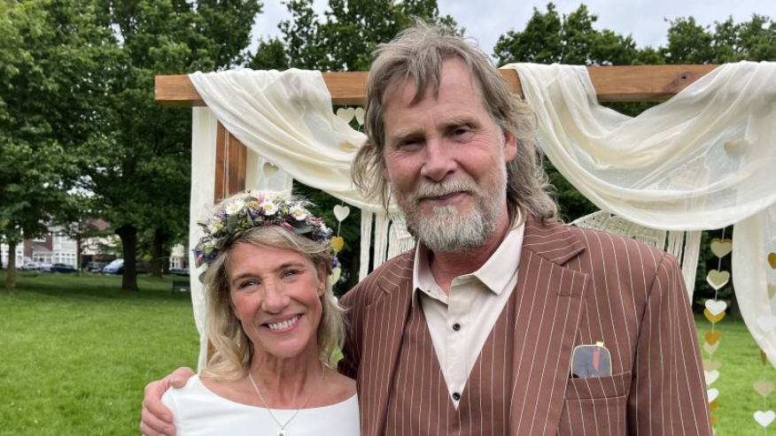 John and Sally-Anne stand in front of the wedding arch on victoria park, leicester 