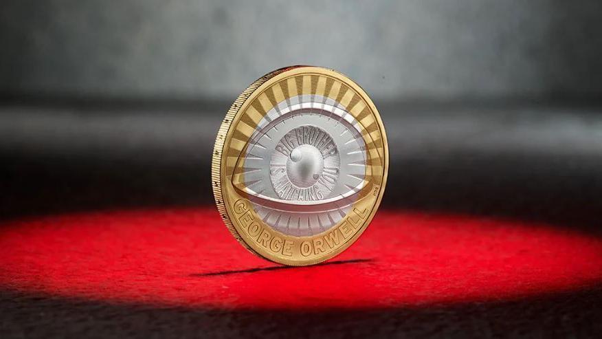 The coin's design - eye encircles the lens with inscription ‘BIG BROTHER IS WATCHING YOU’ and the name of the author.