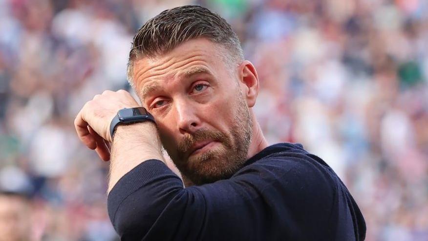 Luton manager Rob Edwards wipes away a tear after the defeat by West Ham