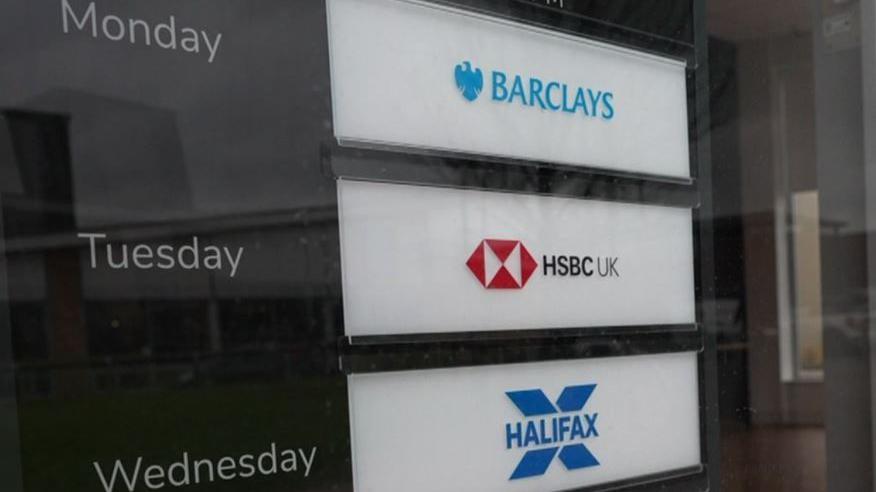 The outside of a banking hub which has signs for Barclays where staff are available on Monday, sign for HSBC on Tuesdays and Halifax on Wednesdays.