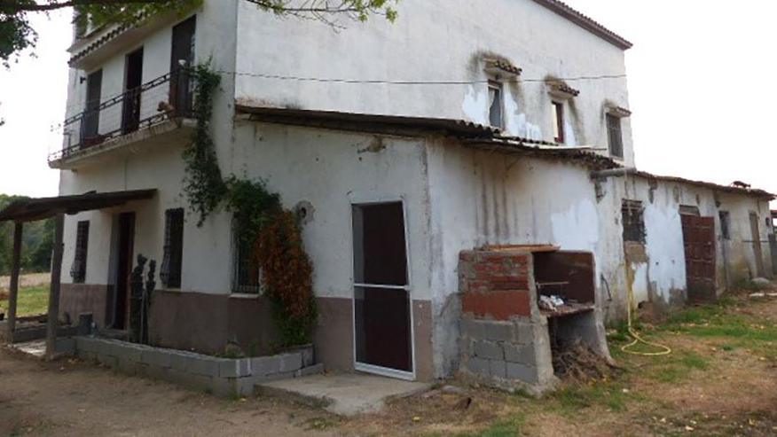 The exterior of a Spanish farmhouse featuring a white wall