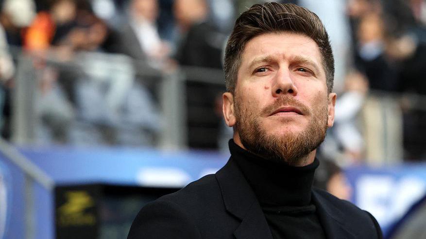 Head and shoulders view of a bearded Sebastien Pocognoli in black rollneck jumper and dark smart jacket