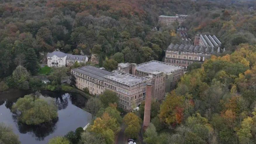 An aerial image of Pleasley Vale Business Park - which is a series of 18th century mills next to a river.