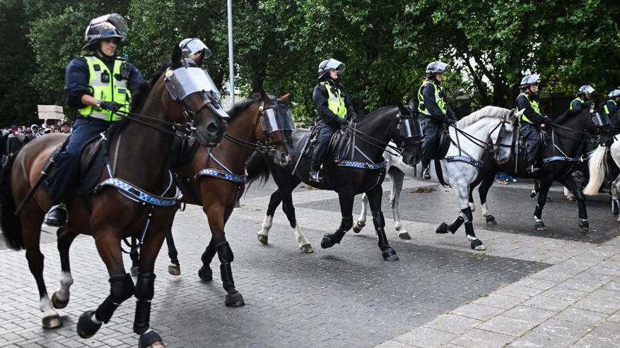 Police officers on five horses in a street in Bristol 