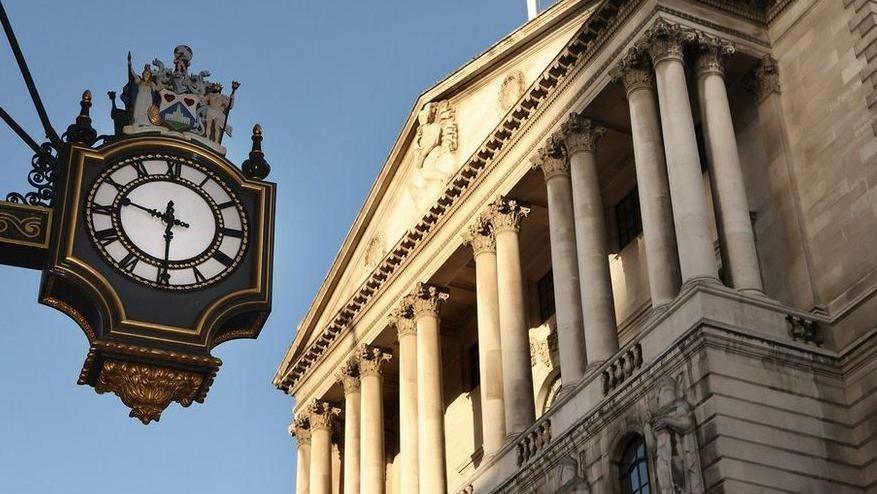 Angled shot of the exterior of the white stone Bank of England building in London