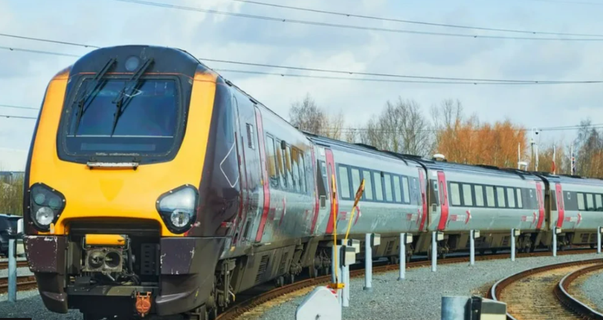 An inter-city train on tracks on a grey day.