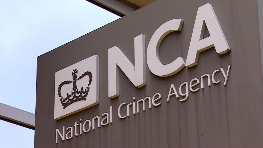 Sign for the NCA headquarters - it is white lettering against a grey background