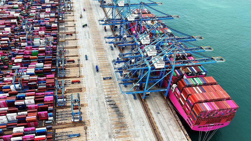 Overhead view of a container ship in a container port with many containers on the ship and also on the port side waiting to be loaded
