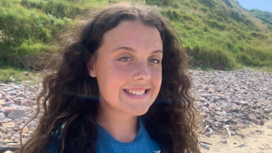 Lucy smiling at a beach