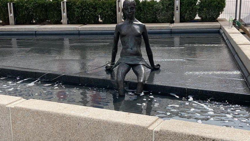 The Naiad statue in Coventry and a man next to it