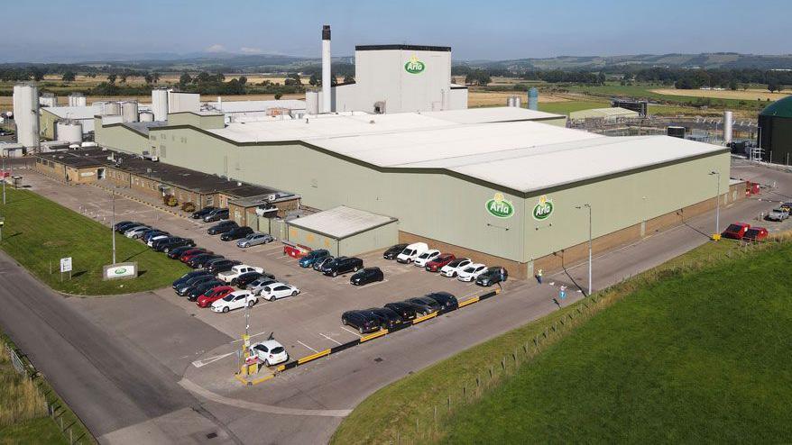 An industrial dairy building and car park set in the south of Scotland countryside