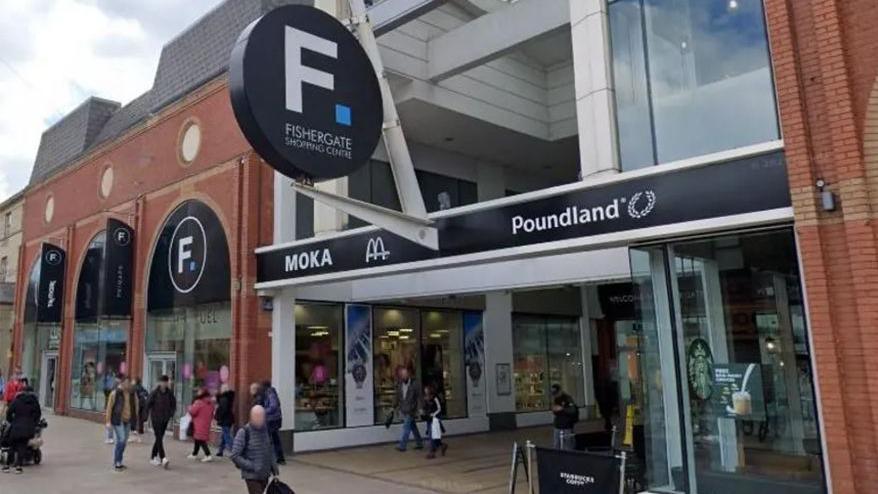 Street view of Fishergate Shopping Centre entrance with shoppers milling round the entrance