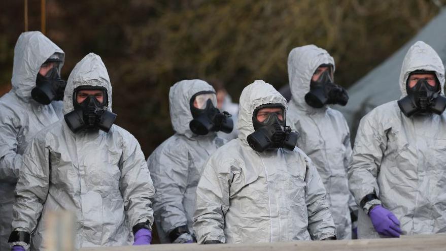 Personnel in protective coveralls and breathing equipment work at the Salisbury District Hospital in March 2018 after a man and a woman were poisoned in a nerve agent attack