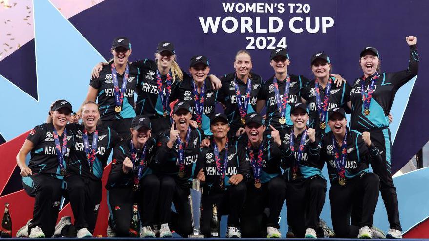 New Zealand's players pose with the T20 World Cup trophy in 2024