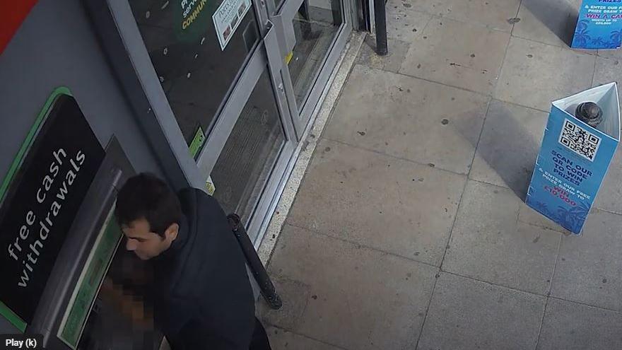 A man tampering with a cash machine seen on CCTV.