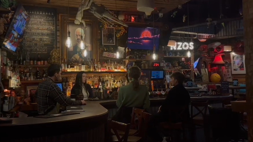 The inside of Gonzo's Two Room. There are four people sat at a bar which is dimly lit. 