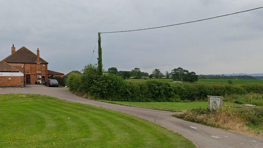 Horse Leys Farm - a Streetview image showing a red brick farmhouse at the end of a short road, overlooking fields and hedges