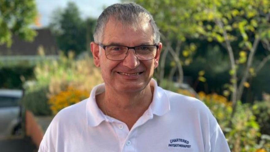 Rob Hodgkiss wearing a polo shirt embroidered with chartered physiotherapist