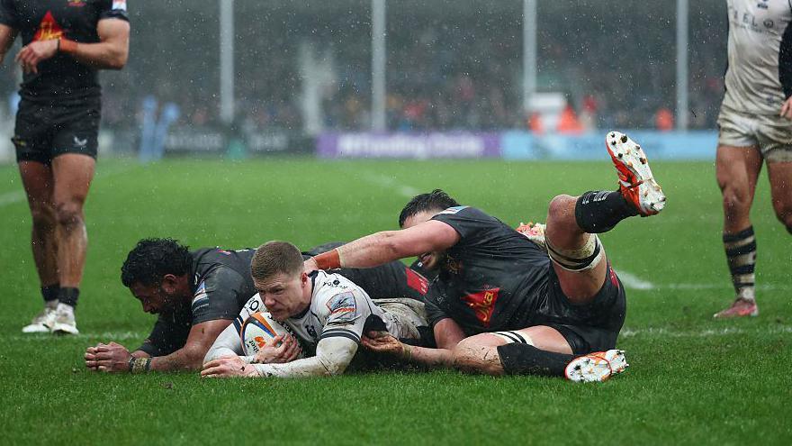 Noah Heward of Bristol dives over the line to score a try against Exeter Chiefs at a sodden Sandy Park.