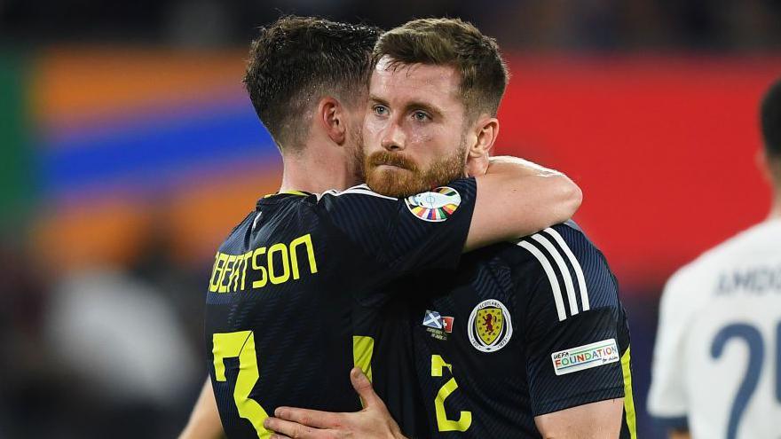 Anthony Ralston is embraced by captain Andy Robertson