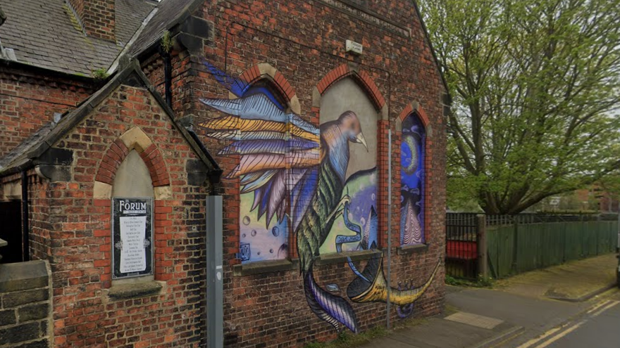 Exterior of The Forum with a colourful bird mural across it