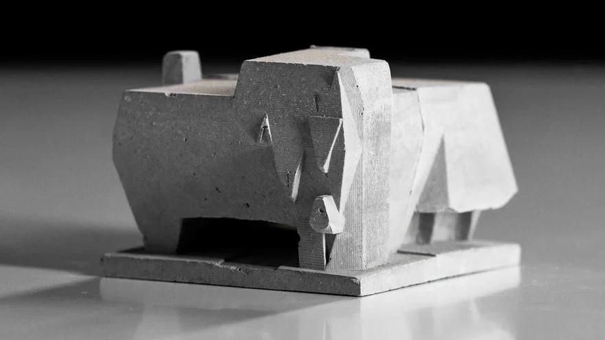 A model of the Elephant building which is shaped like an elephant and is made of concrete. The sculpture stands on a square plinth on top of a mirrored surface.