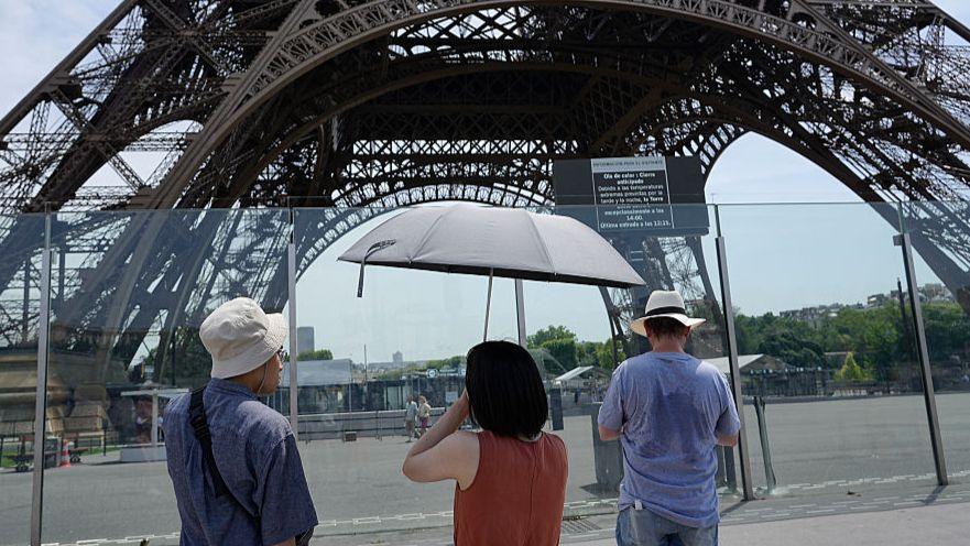 Tourists arrive at a closed Eiffel tower during a heat wave