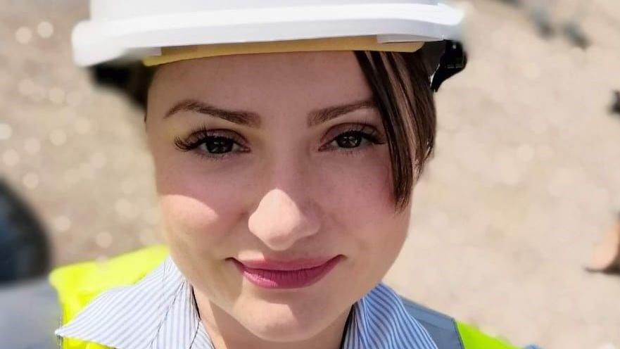 Headshot of Jennifer Nadia Alemanno wearing a white hard hat and yellow hi-viz vest