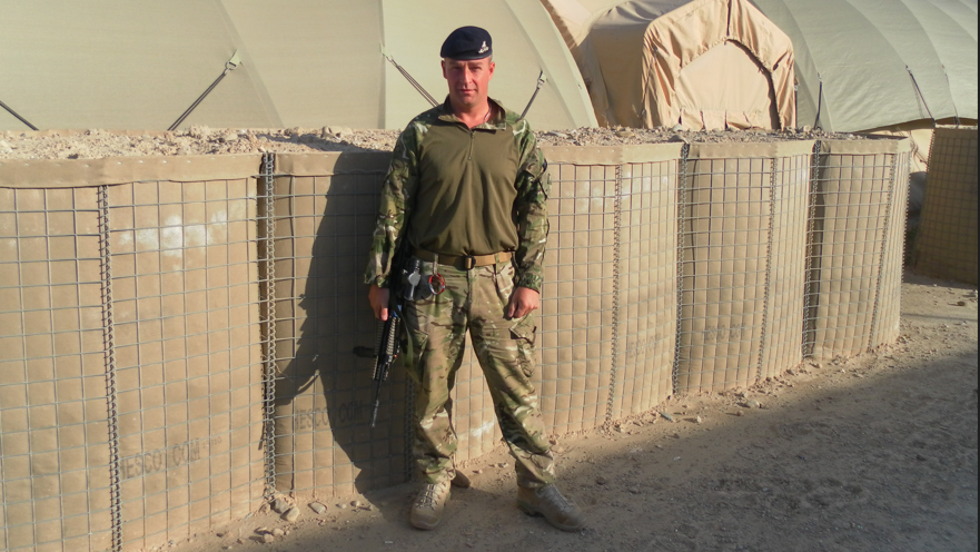 A picture of a man outside a tent in Afghanistan