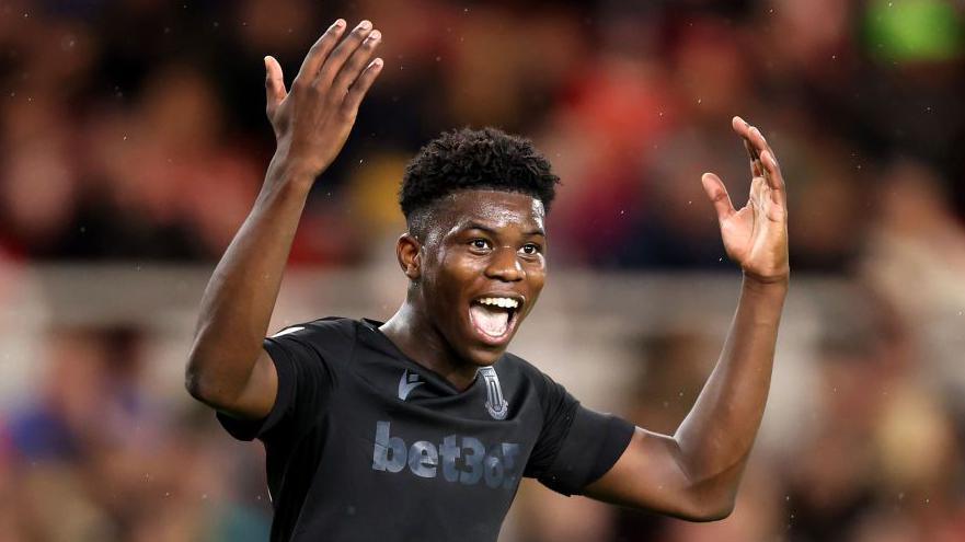 Sol Sidibe celebrates with his arms aloft while playing for Stoke