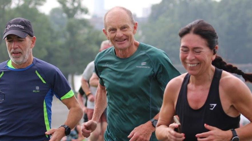 Parkrun Ireland manager running alongside a man and a woman